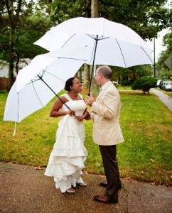 a bride and groomshare their first look in their front yard under giant white umbrellas