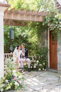 Bride and Groom sitting on a garden bench for their first look - Bellwether Events