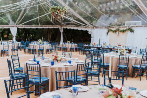 Tented wedding reception with blue chairs - Bellwether Events