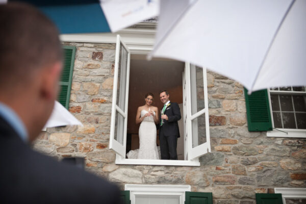 Private residence wedding: Bride and groom looking out a window during a rainy wedding day, planned by Bellwether Events, Washington DC